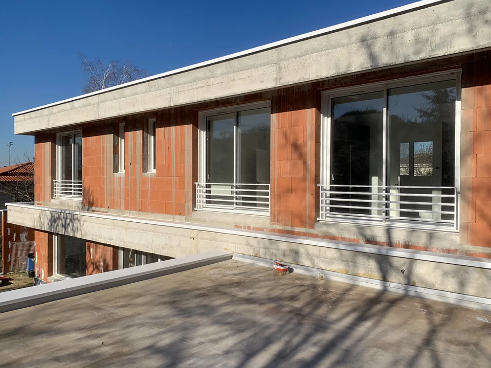 Vue aérienne d'une terrasse de toit moderne avec piscine rectangulaire à débordement, entourée de margelles en bois composite
