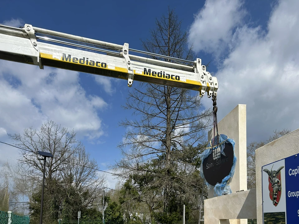 Ouvrier asiatique vérifiant la qualité derrière une machine industrielle à l'intérieur de l'usine