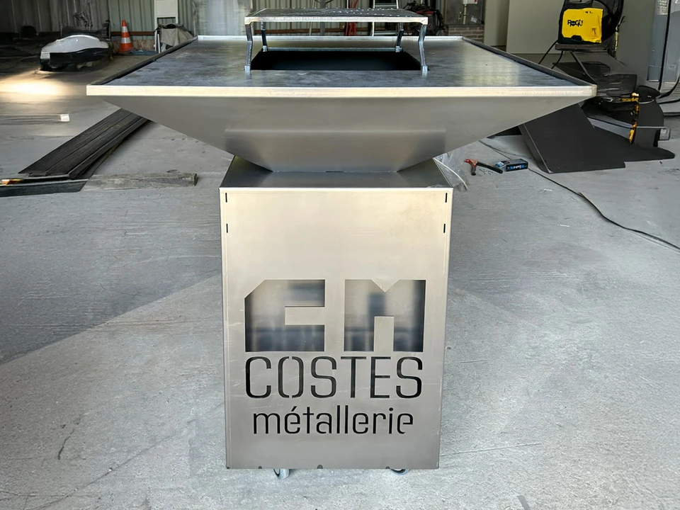 Projection intense d'étincelles incandescentes orange et dorées sur fond noir, particules en mouvement dispersées dans l'espace, source lumineuse concentrée visible côté droit