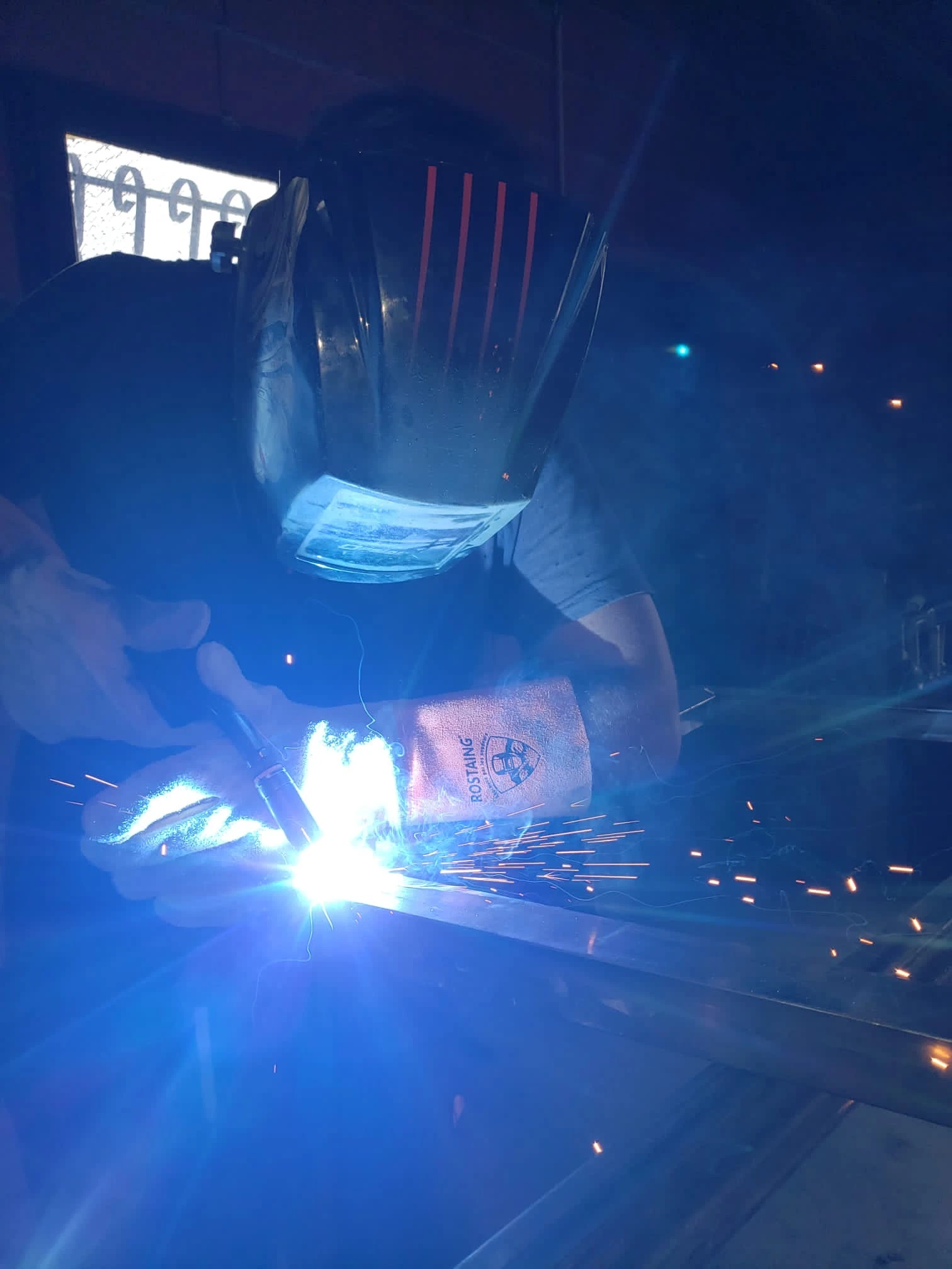 Atelier de m&eacute;tallurgie avec projection d'&eacute;tincelles incandescentes dans l'obscurit&eacute;